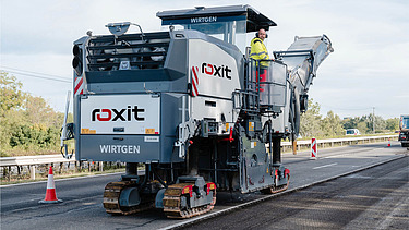 Road milling machine and soil stabilizer in use on unpaved routes for removing and preparing road surface material