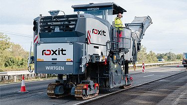 Road milling machine and soil stabilizer in use on unpaved routes for removing and preparing road surface material