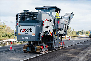 Road milling machine and soil stabilizer in use on unpaved routes for removing and preparing road surface material
