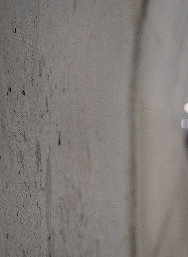 Detailní záběr na betonovou stěnu v tubusu metra