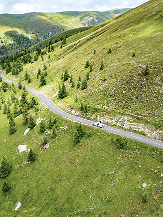 Aerial view of a road in an Alpine mountain landscape. The image accompanies content on the topic of sustainability and responsibility at STRABAG.